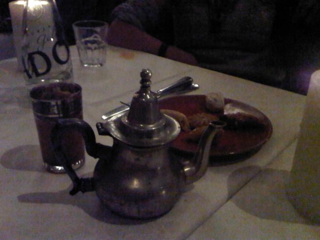 Moroccan pot of tea with mint leaves and a plate of sweets...